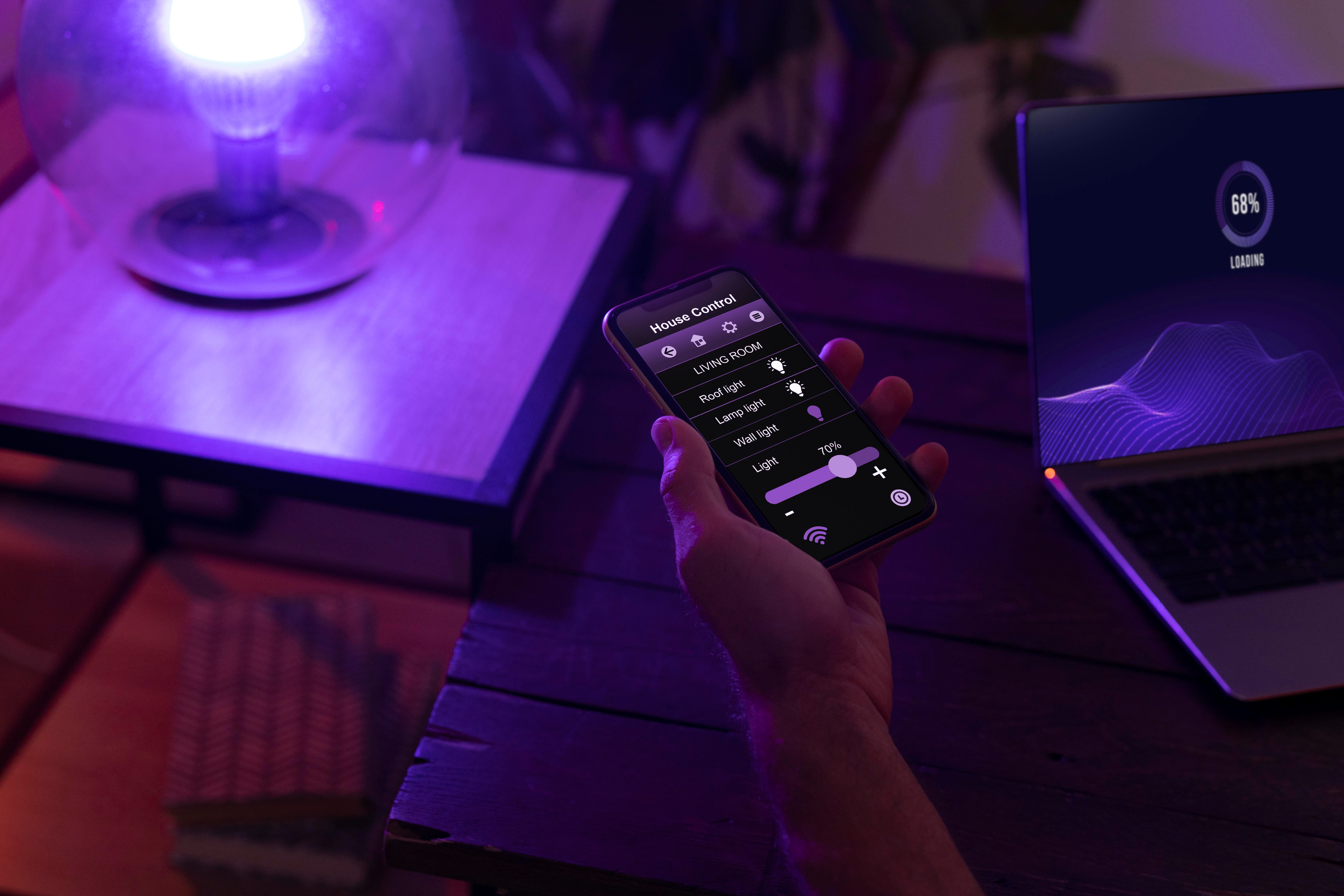 erson controlling Govee smart LED lights using a mobile smartphone app in a modern living room